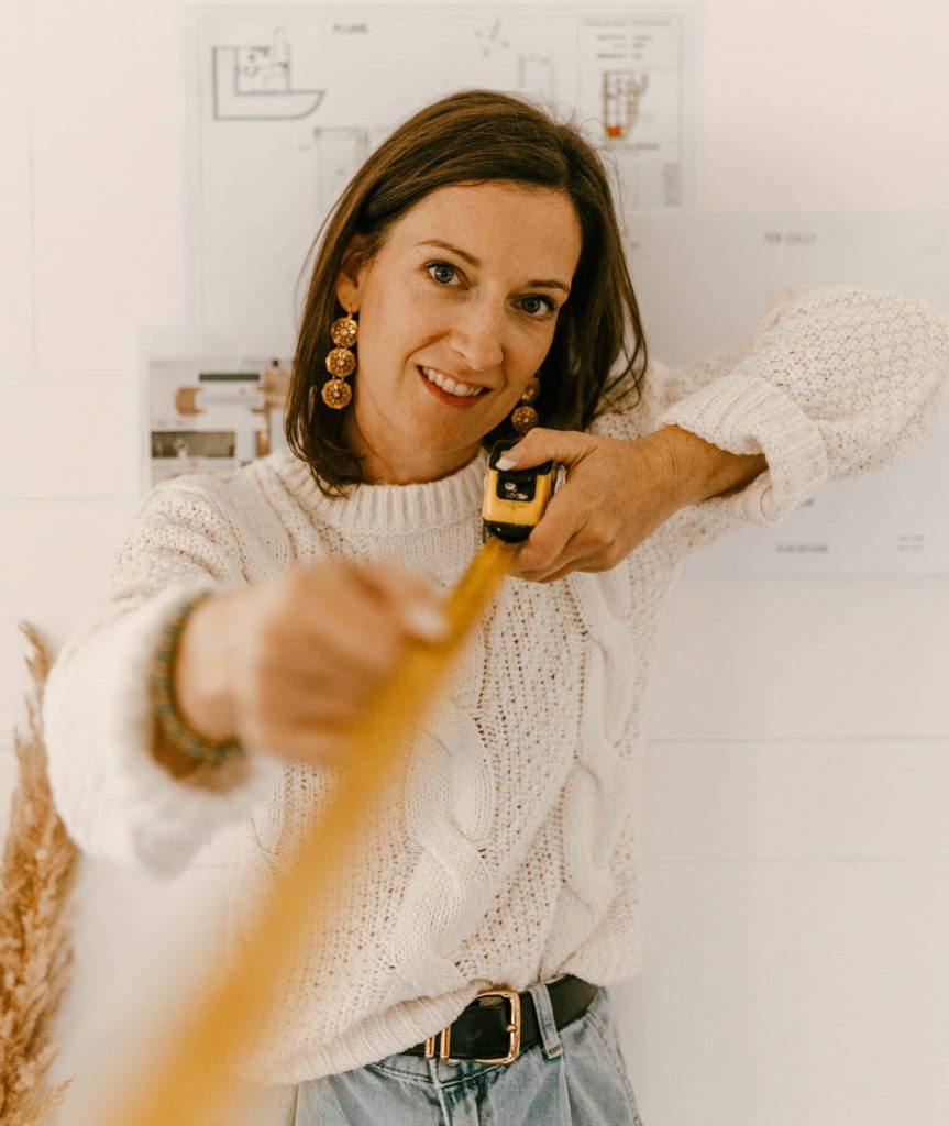 Femme mesurant une pièce avec un mètre