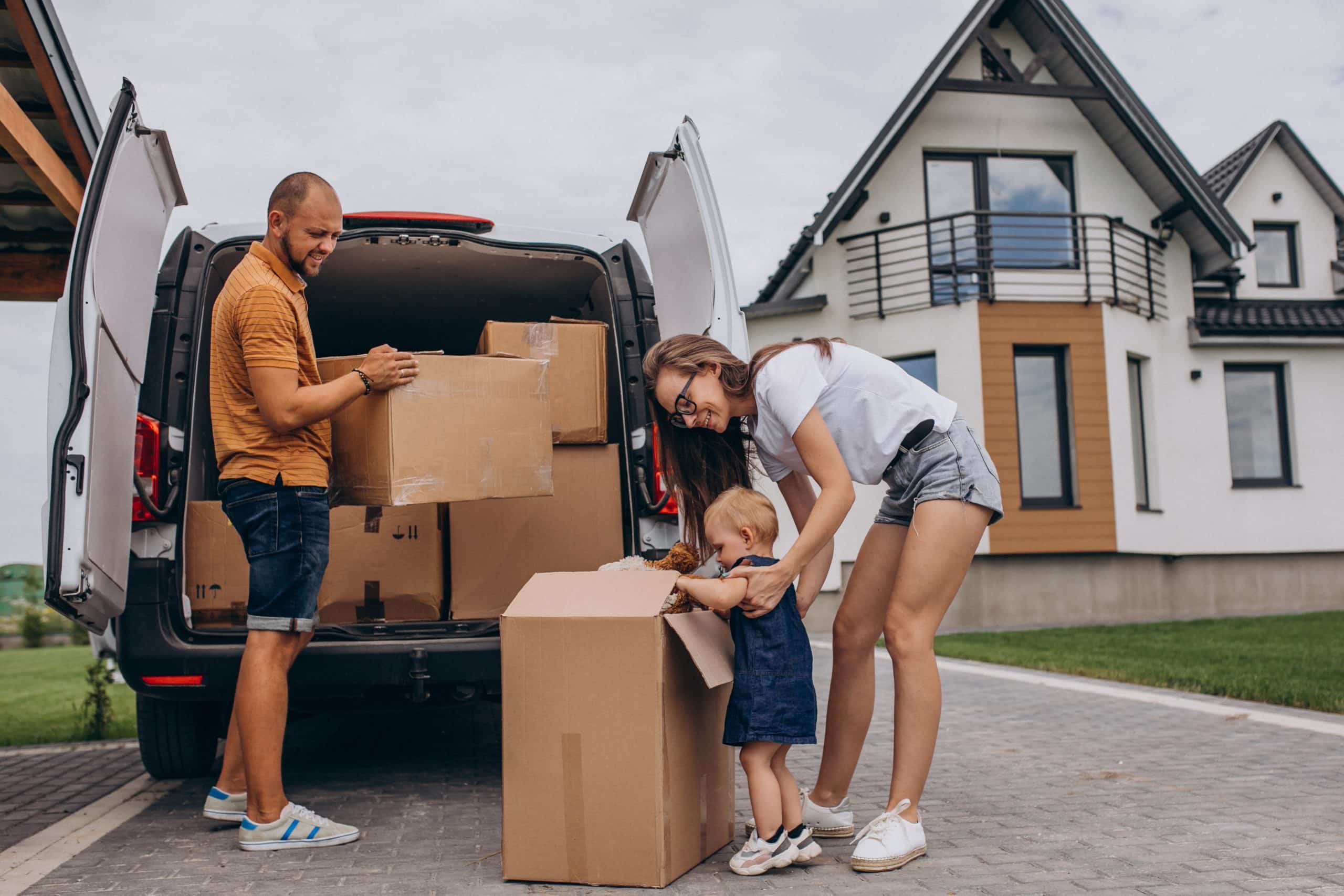 Famille emménageant dans sa nouvelle maison et déchargeant des cartons du camion