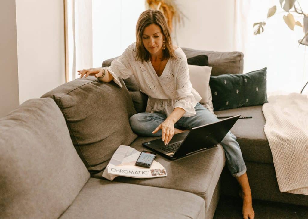Femme assise sur un canapé utilisant un ordinateur