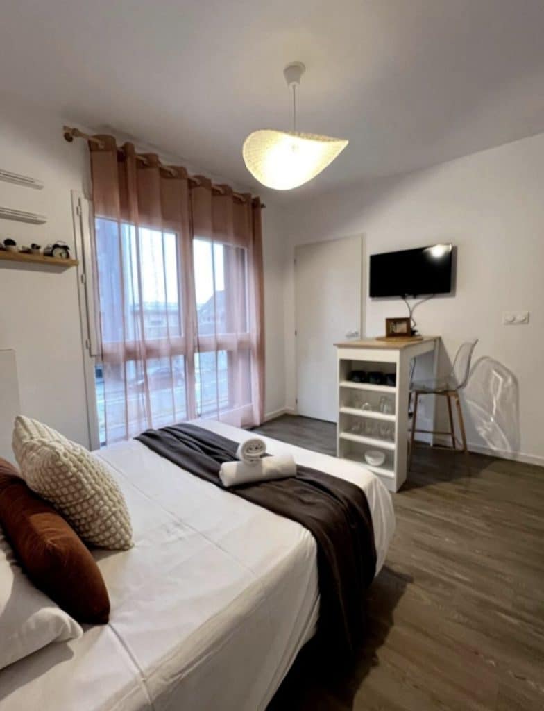 Chambre décorée avec un lit, un meuble et une télévision